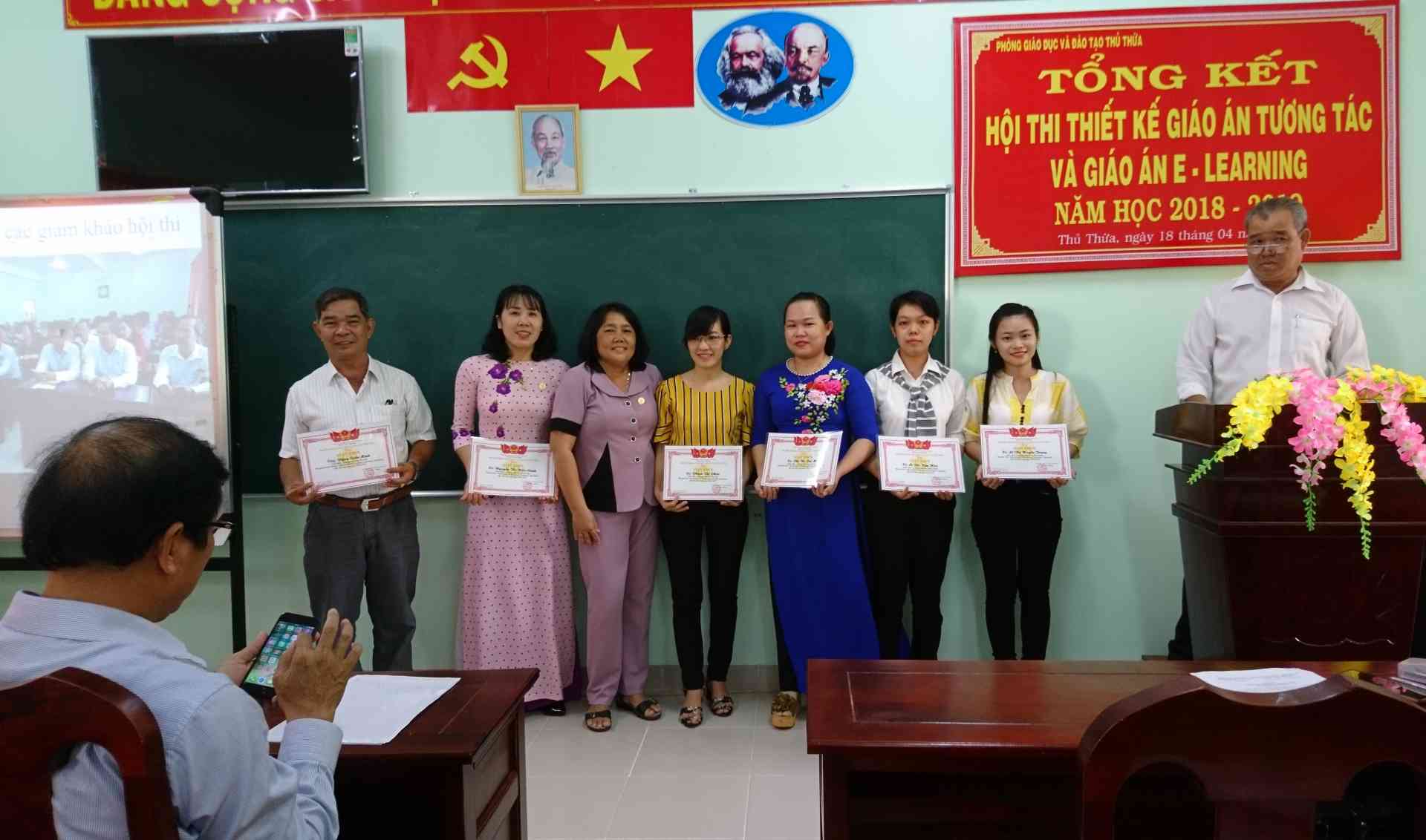 Hiệu trưởng Trung học cơ sở Thị trấn Thủ Thừa, đứng thứ 3 từ trái qua, trao giáy khen cho các giáo viên Tiểu học đạt giải