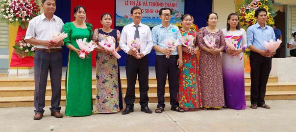 Hiệu trưởng và giáo viện khối lớp 9 nhận hoa của học sinh